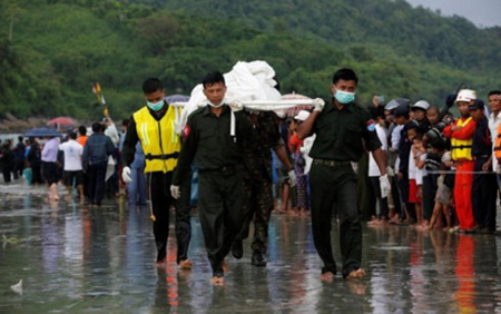 Binh sỹ khiêng thi thể nạn nhân vụ tai nạn máy bay ở Myanmar ngày 7/6 vừa qua.